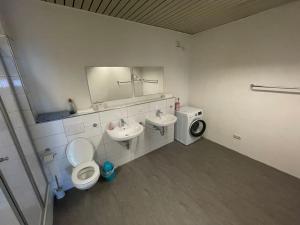 ein Badezimmer mit einem WC, einem Waschbecken und einem Spiegel in der Unterkunft Monteursparadies 4 DZ, 2 Bäder, einfach gut in Haßloch