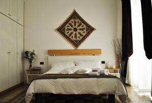 una camera da letto con un grande letto con un'immagine appesa alla parete di B&B Ai Tintori a Palermo
