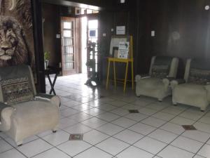 una habitación con sillas y un león en la pared en Keimoes Hotel, en Keimoes