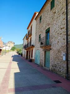 - un bâtiment en pierre avec des portes bleues dans une rue dans l'établissement Vivalidays Casa Rural Anna Mieres Gerona, à Mieras