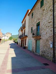 a stone building with blue doors on a street at Vivalidays Casa Rural Anna Mieres Gerona in Mieres