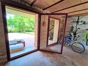 Habitación con ventana y bicicleta en la pared en Vivalidays Casa Rural Anna Mieres Gerona en Mieras
