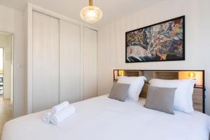 1 Schlafzimmer mit 2 Betten und weißen Kissen in der Unterkunft Le rayonnant du Placieux avec parking privé in Nancy