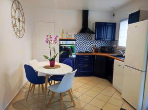 une cuisine avec une table blanche et des chaises bleues dans l'établissement Maison confort Trégomeur avec jardin et parking, à Trégomeur 20 autres photos
