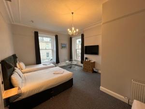 1 dormitorio con cama y lámpara de araña en Lost Guest House Aberdeen, en Aberdeen