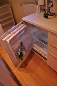 an empty refrigerator with a bottle inside of it at Apartment am Bürgerpark in Bremerhaven