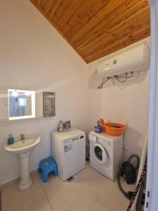 a bathroom with a washing machine and a sink at Villa Mari in Makris Gialos