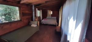 Habitación pequeña con cama y ventana en Titania Traful en Villa Traful