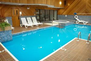 a large swimming pool with blue water in a building at Super 8 by Wyndham Campbellton NB in Campbellton