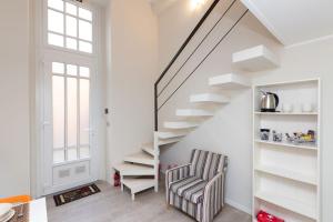 escalera blanca con silla a rayas en la sala de estar en In Verticale, en Turín