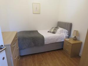 a small bedroom with a bed and a night stand at Beautiful 3-Bed Cottage in Llancarfan Nr Cardiff in Barry
