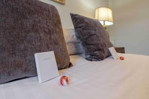 a book sitting on top of a bed with pillows at Craignish Apartments in Falkirk