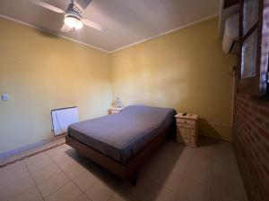 ein kleines Schlafzimmer mit einem Bett und einem Nachttisch in der Unterkunft La Casa del Escritor in Colastiné