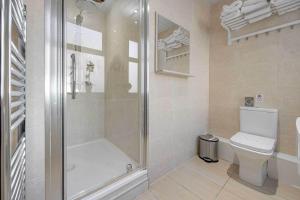 La salle de bains est pourvue d'une douche et de toilettes. dans l'établissement Craignish Apartments, à Falkirk