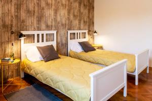 two beds in a room with wooden walls at Angelina's garden place, max 6 persons, near Pula in Marčana
