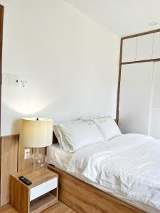 a bedroom with a bed and a lamp on a night stand at Riverside LK HOME Phú Nhuận 2 in Ho Chi Minh City