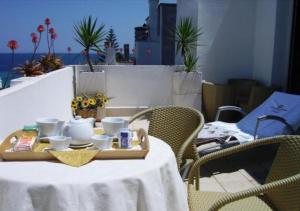 una mesa con una bandeja con tazas y tazas. en Hotel Degli Haethey, en Otranto