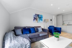 a living room with a gray couch and blue pillows at 2 Bedroom Penthouse with parking High Wycombe By 360Stays in High Wycombe