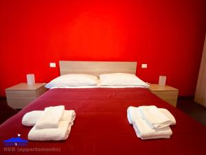 a red bedroom with a bed with towels on it at About Toledo in Naples