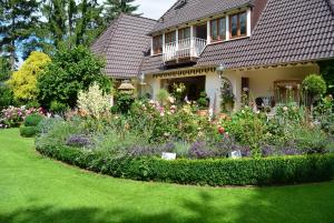 a garden in front of a house with flowers at Apartment am Bürgerpark in Bremerhaven