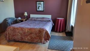 a hotel room with a bed and a chair at Motel Rayalco in Laurier Station