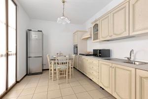 uma cozinha com uma mesa e um frigorífico de aço inoxidável em La Villa em Mântua