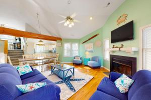 sala de estar con sofá azul y chimenea en Crustacean Sensation CL12 en Corolla