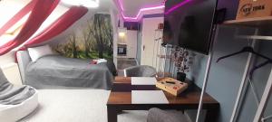 a bedroom with a bed and a table and a tv at Best-Preis -VIP Lounge- mit Netflix, Self-Check-In, eBike Ladestation, Fahrradraum, WLAN und Netflix - direkt am Elberadweg im Herzen von Wittenberge in Wittenberge