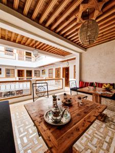 un soggiorno con tavolo in legno e divano di Riad El Pacha a Rabat