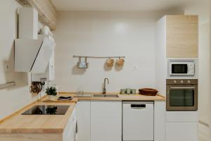 Apartamento Vara de Rey في لوغرونيو: مطبخ مع دواليب بيضاء ومغسلة
