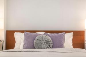 a bedroom with a bed with purple pillows at Exclusive Csengery Residence in the heart of Budapest in Budapest