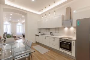 a white kitchen with white cabinets and appliances at Exclusive Csengery Residence in the heart of Budapest in Budapest