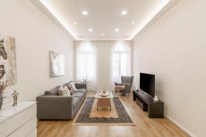 a living room with a couch and a tv at Exclusive Csengery Residence in the heart of Budapest in Budapest