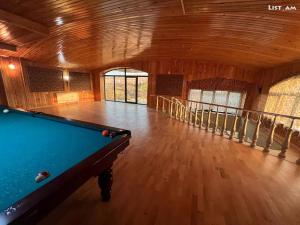 una mesa de billar en una habitación grande con suelo de madera en Happy home guest house, en Fantan