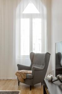 a living room with a chair and a window at Exclusive Csengery Residence in the heart of Budapest in Budapest