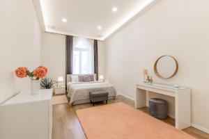 a white bedroom with a bed and a mirror at Exclusive Csengery Residence in the heart of Budapest in Budapest
