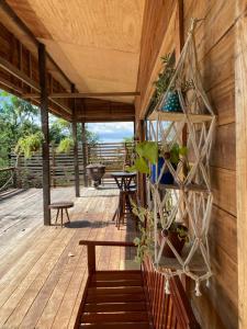 een houten terras met banken en planten erop bij Casa Bené Ilha do Combu Amazônia Belém in Belém