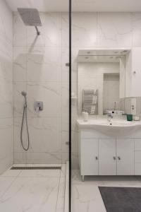 a white bathroom with a shower and a sink at Exclusive Csengery Residence in the heart of Budapest in Budapest
