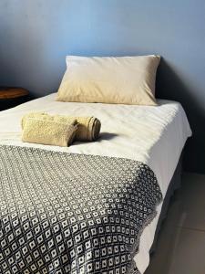 a bed with a black and white comforter and pillow at Etosha/Omuthiya 2 Bedroom in Omuthiya