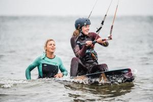 a woman and a girl on a board in the water at The Beach House-Devon- On the beach- sleeps 20 in Exmouth