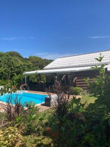 une maison avec une piscine dans une cour dans l'établissement Eden des laves, à Sainte-Rose