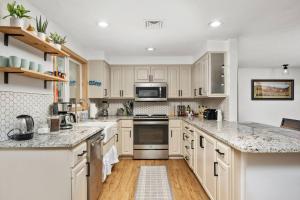 a kitchen with white cabinets and marble counter tops at Tulip Street Retreat in Eugene