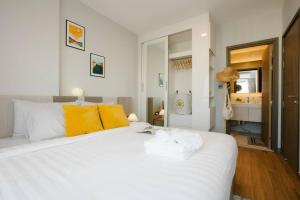 - une chambre avec un grand lit blanc et des serviettes dans l'établissement Sky River, Luxury Infinity, Center Chiang Mai, à Chiang Mai