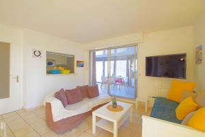 un soggiorno con divano e TV di Appartement Terrasse vue Mer a Canet-en-Roussillon
