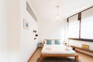 a white bedroom with a bed and a bench at Marcona Apartment in Milan