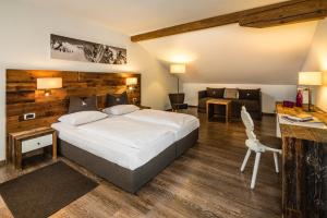 a hotel room with a bed and a desk at Hotel ANDER in Brunico