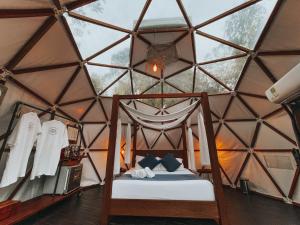 una camera da letto in una tenda a cupola con un letto in esso di Domus Glamping a Guatapé