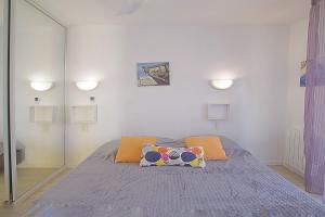 una camera con un letto con due cuscini sopra di Appartement Terrasse vue Mer a Canet-en-Roussillon