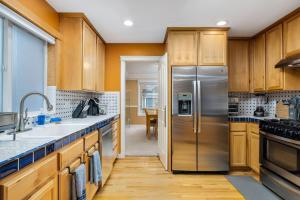 Una cocina con gabinetes de madera y un refrigerador de acero inoxidable. en Seiben Creek Retreat, en Clackamas