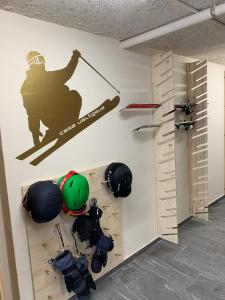 ein Zimmer mit einer Wand mit Skiausrüstung drauf in der Unterkunft Casa Valtgeva in Sedrun